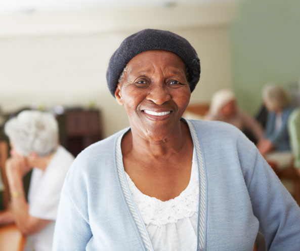 Smiling african american woman with tables of people in the background.